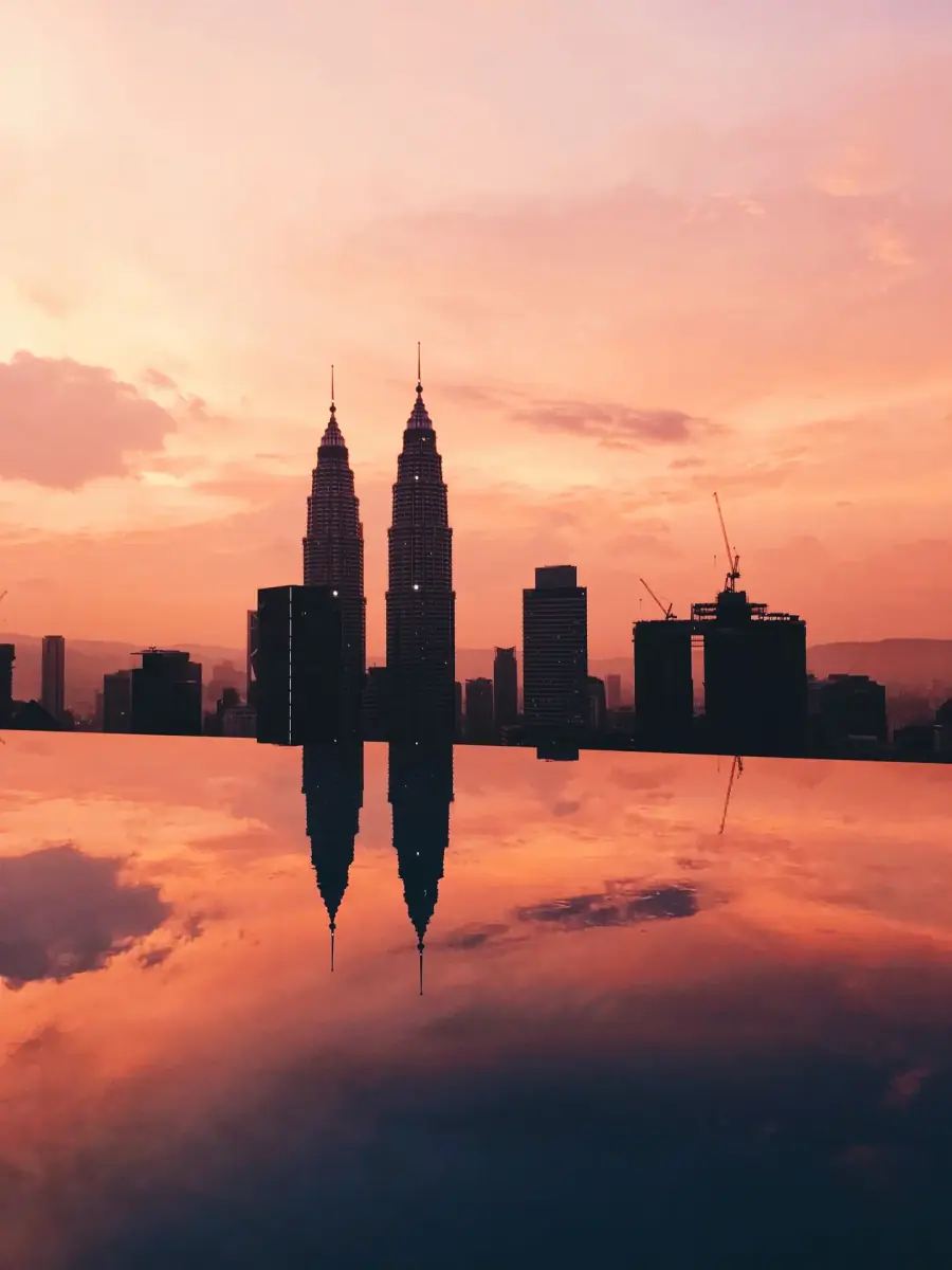 Petronas Twin Towers illuminated reflections across park pool in Kuala Lumpur